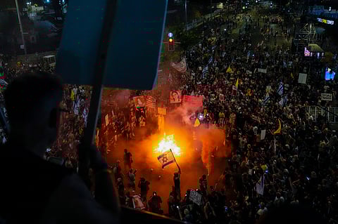 A demonstrator waves the Israeli and U.S. flags during a protest against Prime Minister Benjamin Netanyahu's government and call for the release of hostages held in the Gaza Strip by the Hamas militant group.