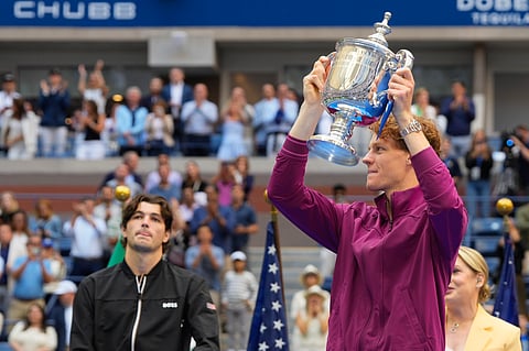 Jannik Sinner, of Italy, holds the championship trophy as Taylor Fritz, of the United States, looks on after sinner won the men's singles final of the U.S. Open tennis championships, Sunday, Sept. 8, 2024, in New York.