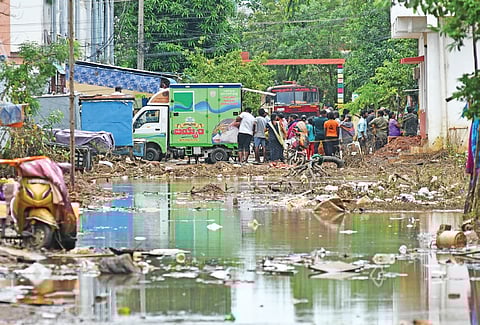 Garbage accumulated on the roads of YSR colony near Vijayawada after flood water recedes on Tuesday