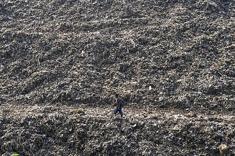 A wastepicker walks past on a pile of garbage at a landfill in Depok on the outskirts of Jakarta, Indonesia, May 10, 2024.