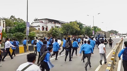 Members of All Manipur Students' Union (AMSU) charge towards a CRPF convoy during a protest march against the recent violence in the state, in Imphal.