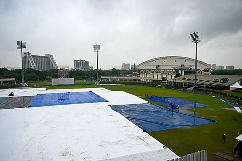 Groundsmen remove the field's cover after the one-off Test cricket match between Afghanistan and New Zealand was called off, at the Shaheed Vijay Singh Pathik Sports Complex in Greater Noida on September 13, 2024.