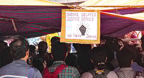A poster hangs at the protest site as junior doctors continued their 'cease work' and sit-in demonstration against the RG Kar Hospital incident for the third consecutive day, outside Swasthya Bhavan in Kolkata, Friday, Sept. 13, 2024.