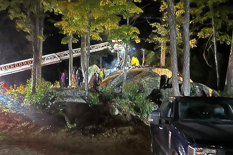 This Sunday, Sept. 15, 2024 photo provided by the Hillsborough Fire Department shows first responders at the scene of a rescue for a child who became wedged between two boulders, in Windsor, N.H.