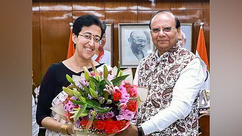 Delhi L-G V K Saxena with AAP leader Atishi