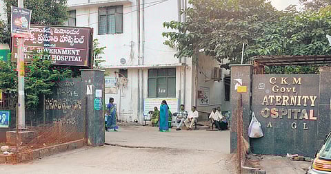 Patients and their attenders wait in front of the CKM hospital in Warangal
