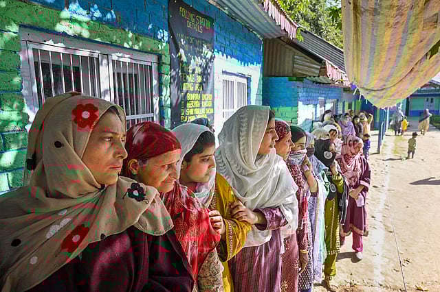 Women wait in a queue to cast his their votes at a polling booth during the first phase of Jammu and Kashmir Assembly elections.