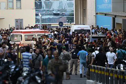 Ambulances are surrounded by people at the entrance of the American University of Beirut Medical Center, on September 17, 2024, after explosions hit locations in several Hezbollah strongholds around Lebanon