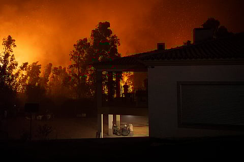 A silhouette of a woman watching a wildfire is pictured as it approaches Veiga village in Agueda, Aveiro on September 17, 2024.