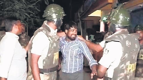 Police secure an accused in Davanagere on Thursday night