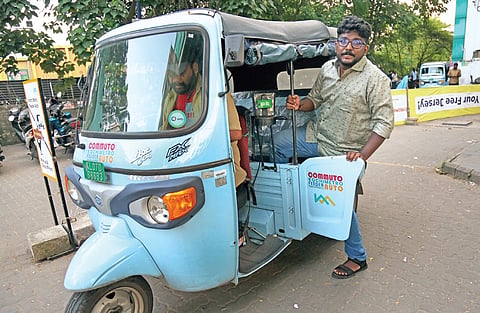 A passenger boards an e-feeder autorickshaw at JLN metro station