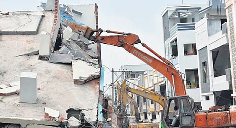 Earthmovers demolish illegal buildings on government lands in Ameenpur on Sunday