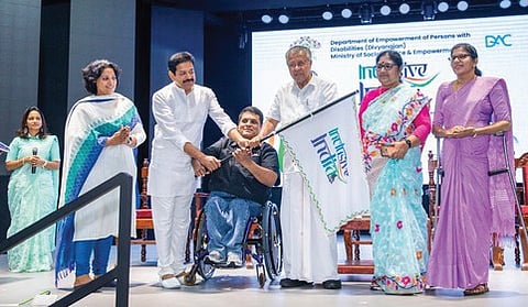 Chief Minister Pinarayi Vijayan hands over the India Inclusive travel campaign flag to Gopinath Muthukad and Boniface Prabhu