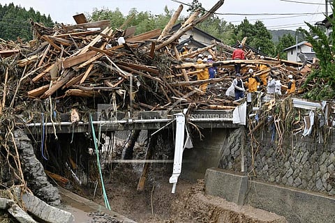 Rescuers search where houses were swept away along a river in Wajima, Japan, Sunday, Sept. 22, 2024, following heavy rain in central Japan's Noto peninsula area, where a devastating earthquake took place on Jan. 1. (Muneyuki Tomari/Kyodo News via AP)