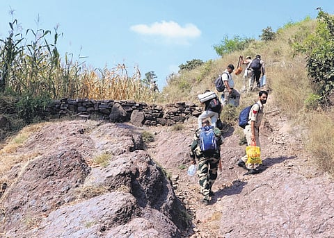 Polling officials scale a difficult terrain to reach their respective polling stations in Rajouri district, a day before the second phase of J&K assembly elections.