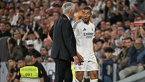 Kylian Mbappe talks with Real Madrid's coach Carlo Ancelotti as he leaves the pitch during a La Liga match between Real Madrid CF and Deportivo Alaves.