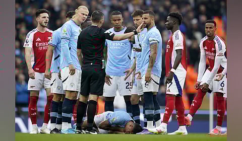 Manchester City's Rodri lies on the pitch after a collision during the English Premier League soccer match between Manchester City and Arsenal at the Etihad Stadium in Manchester, England.