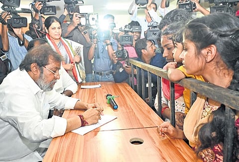 Health Minister Damodar Rajanarsimha reads an application submitted by a visitor at the ‘Meet Your Minister’ programme on Wednesday