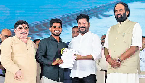Chief Minister A Revanth Reddy hands over an appointment letter to a newly recruited AEE at Jala Soudha in Hyderabad.
