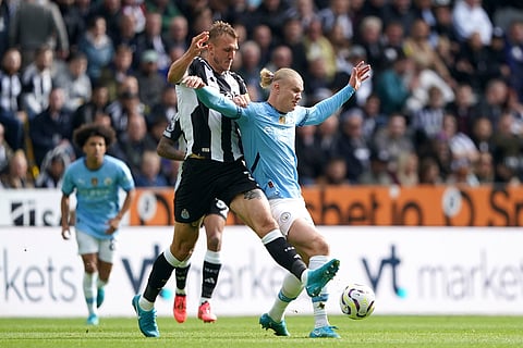 Newcastle United's Dan Burn, left, and Manchester City's Erling Haaland battle for the ball during the Premier League match between Newcastle and Manchester City, at St James' Park, Newcastle.