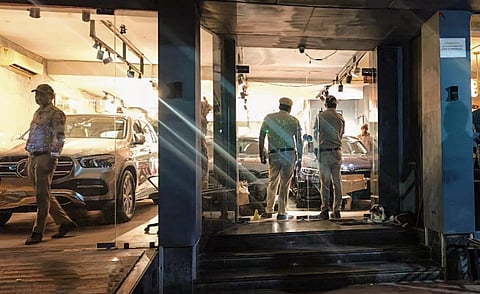 Police personnel investigate after three unidentified assailants opened fire at a car showroom, in Naraina area of New Delhi, Friday night, Sept. 27, 2024.