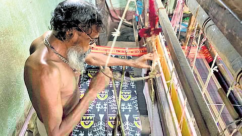 A weaver works on his loom at Maniabandha