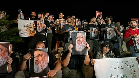 Demonstrators hold pictures of Hassan Nasrallah, late leader of the Lebanese group Hezbollah, during a protest vigil in the southern Lebanese city of Sidon on September 28, 2024.