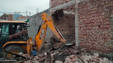 An excavator is used to move the rubble
