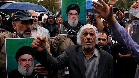 Demonstrators chant slogans as they hold posters of the leader of Lebanon's militant Hezbollah group, Hassan Nasrallah, reading in Arabic, "At your service, Nasrallah" in a gathering to support Hezbollah at the Felestin Square in Tehran, Iran, Saturday, Sept. 28, 2024.