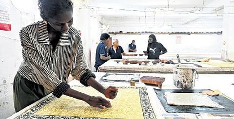 Cindy Rostron, a model from Arnhem Land prints with hand carved woodblocks – designed by the Bábbarra Women’s Centre – at a workshop by Tharangini Studio; (Below) Woodblock design of yawkyawk (mermaid spirit) by artist Deborah Wurrkidj