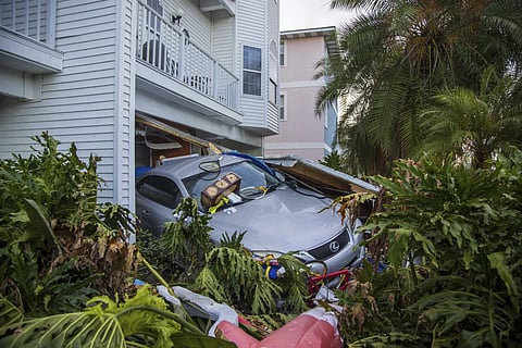 A vehicle sits outside of its garage after storm surge from Hurricane Helene, Saturday, Sept 28, 2024, in Madeira Beach, Fla.