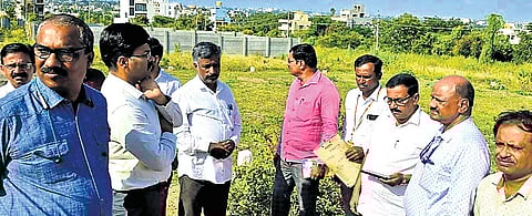 Lokayukta police, activist Snehamayi Krishna and others inspect the land at Kesare, Mysuru, on Tuesday