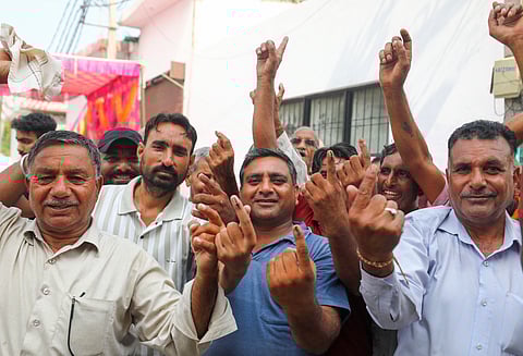 West Pakistani Refugees (WPRs) show their inked fingers after casting their votes during the third and final phase of Jammu & Kashmir Assembly elections