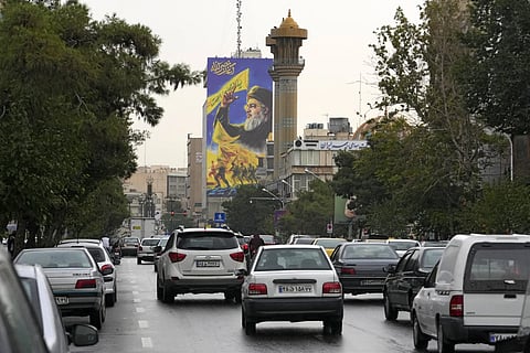 Vehicles drive under a huge portrait of slain Hezbollah leader Hassan Nasrallah, in downtown, Tehran, Iran, Monday, Sept 30, 2024.