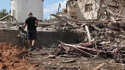 A man and a dog check the rubble of a destroyed building in Hod HaSharon in the aftermath of an Iranian missile attack on Israel, on October 2, 2024.