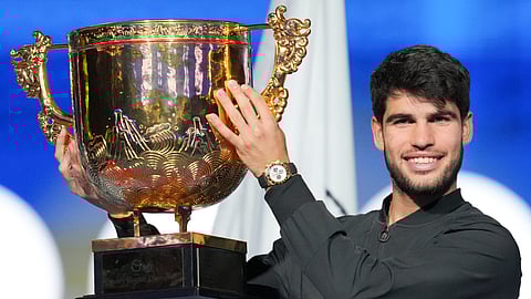 Carlos Alcaraz of Spain poses with his trophy after winning against Jannik Sinner of Italy during their men's singles finals match of the China Open tennis tournament, at the National Tennis Center in Beijing
