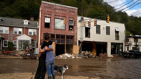 Resident Anne Schneider, right, hugs her friend Eddy Sampson as they survey damage left in the wake of Hurricane Helene, Tuesday, Oct. 1, 2024, in Marshall, N.C.