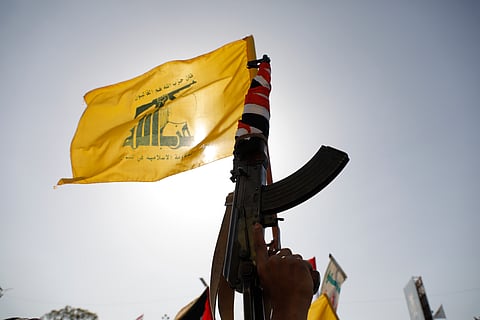 A Houthi supporter raises a Hezbollah flag during an anti-Israel and anti-U.S. rally in Sanaa, Yemen, Friday, Sept. 27, 2024.