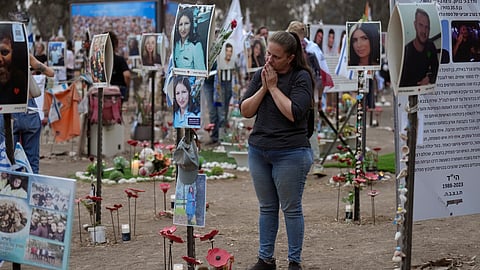 Victoria stands in front a picture of her sister, Yulia Waxer Daunt, as she visits the site of the Nova music festival.