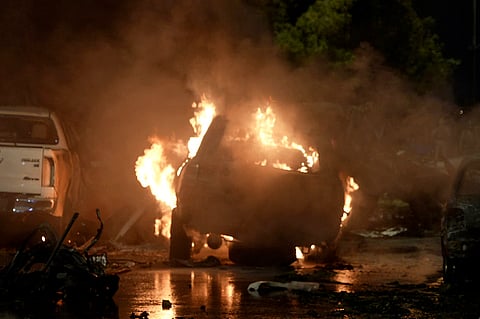 A vehicle is seen on fire at the site of an explosion that caused injures and destroyed vehicles at outside the Karachi airport, Pakistan, Sunday, Oct. 6, 2024.