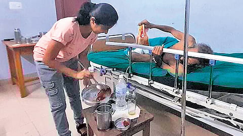 An MBBS student serving food to a patient at the Kannur Government Medical College Hospital.