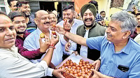 BJP supporters celebrate the saffron party’s victory outside the party office in Amritsar on Tuesday.