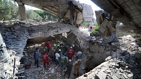 Rescue workers search for victims on shelter for displaced people hit by an Israeli airstrike in Lebanon