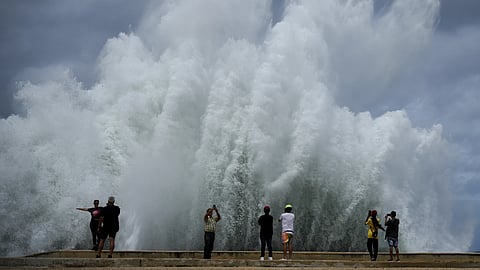 People take photos of the spray from waves crashing against the Malecon seawall, brought by the passing of Hurricane Milton in the Gulf of Mexico, in Havana, Cuba, Wednesday, Oct 9, 2024.