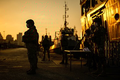 Turkish security officials stand guard next to Turkish military ships preparing to evacuate citizens from Lebanon to Turkey in Beirut port, Wednesday, Oct. 9, 2024.