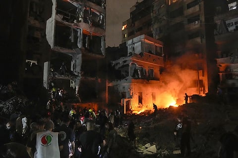 People gather in front of destroyed buildings hit by an Israeli airstrike in central Beirut, Lebanon, Thursday, Oct 10, 2024.