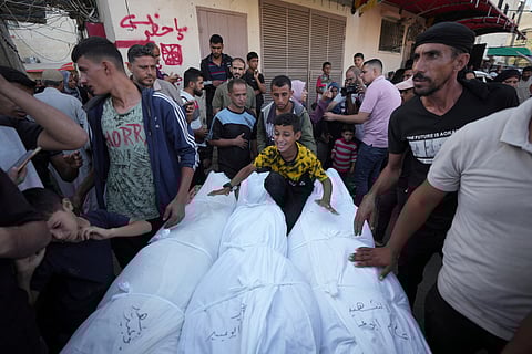 A palestinian kid cries amid dead bodies of family members outside the hospital morgue in Deir al-Balah on Wednesday, Oct. 9, 2024.