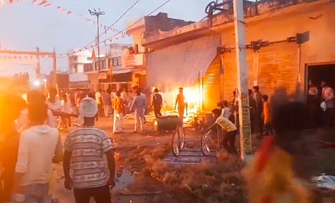People set fire to two-wheelers after a youth died of a gunshot wound during a religious procession carrying an idol of Goddess Durga for immersion, at Mahrajganj Bazar, in UP's Bahraich district.