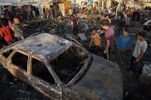 Palestinians look at the damage after an Israeli strike hit a tent area in the courtyard of Al Aqsa Martyrs hospital in Deir al Balah, Gaza Strip.