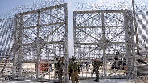 Israeli soldiers gather near a gate to walk through an inspection area for trucks carrying humanitarian aid supplies bound for the Gaza Strip, on the Israeli side of the Erez crossing into northern Gaza.